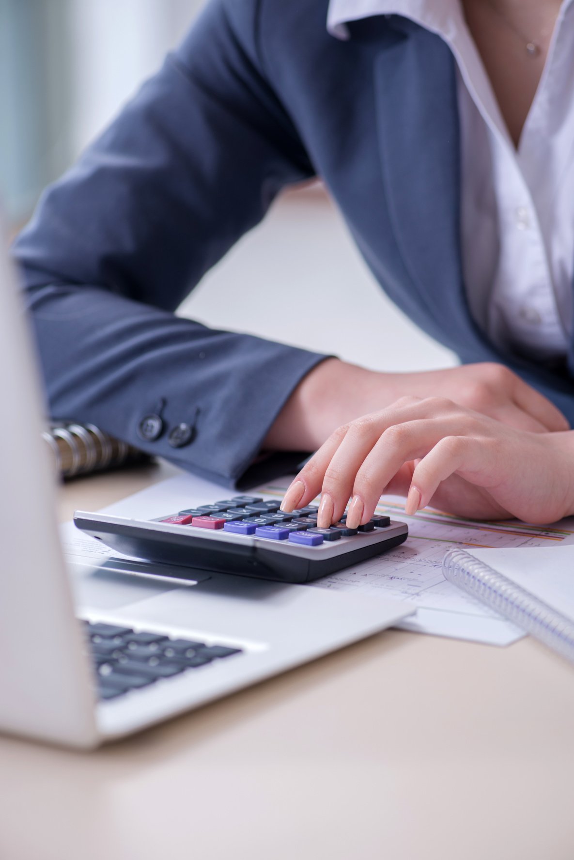 Female Finance Professional Working on Keyboard with Reports